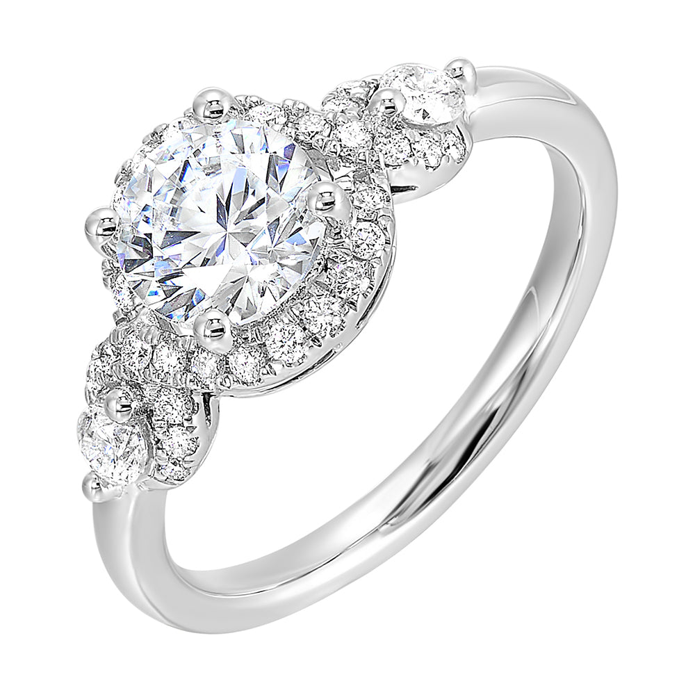 Encircling the base of solitare center with pave of glittering diamonds this three stone ring is sure to enchant her.