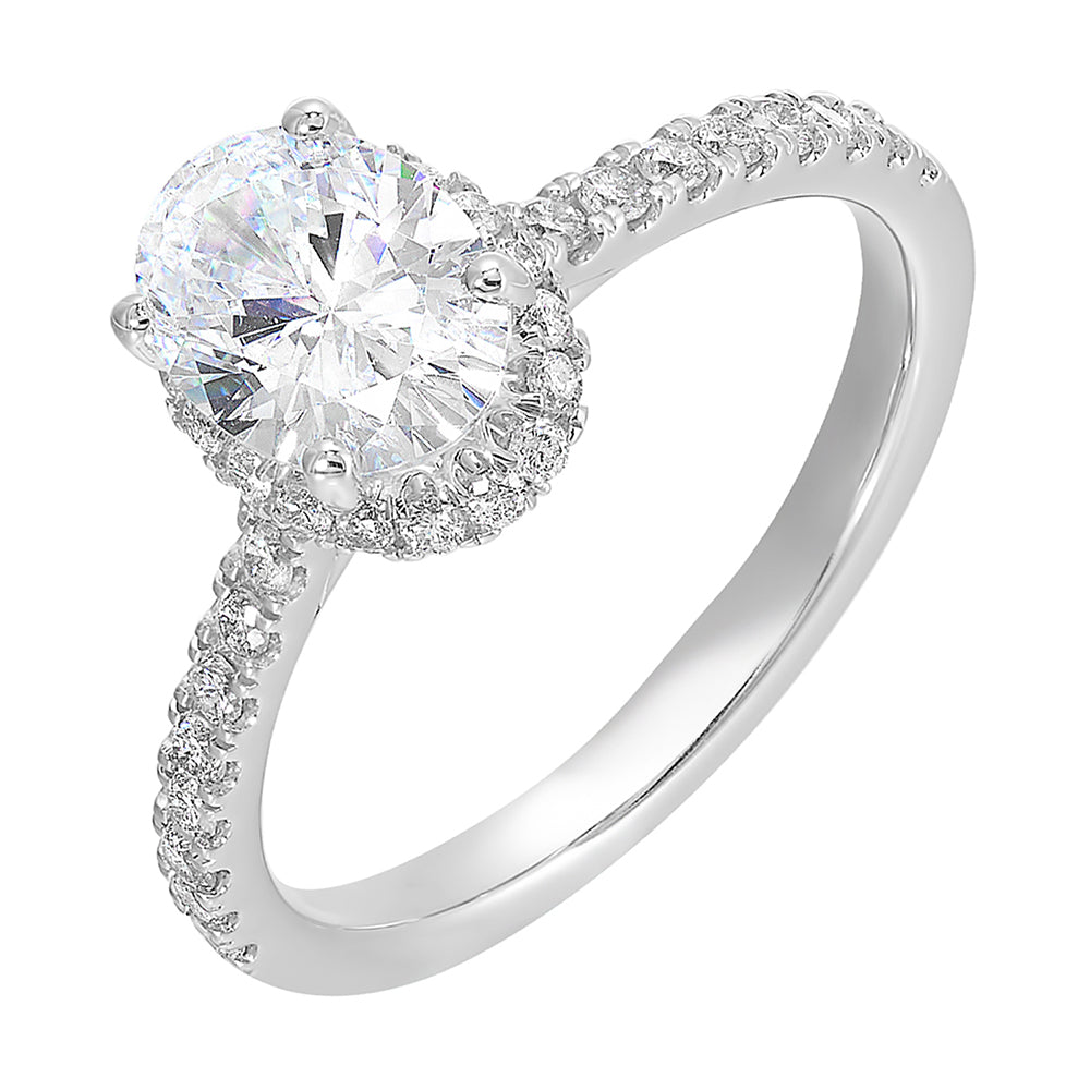 This stunning engagement ring features an oval solitare diamond,  accented by pave set round diamonds on shank and a hidden halo.